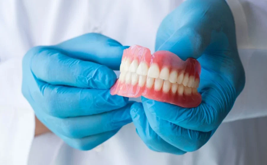Dentist Holding Traditional Dentures